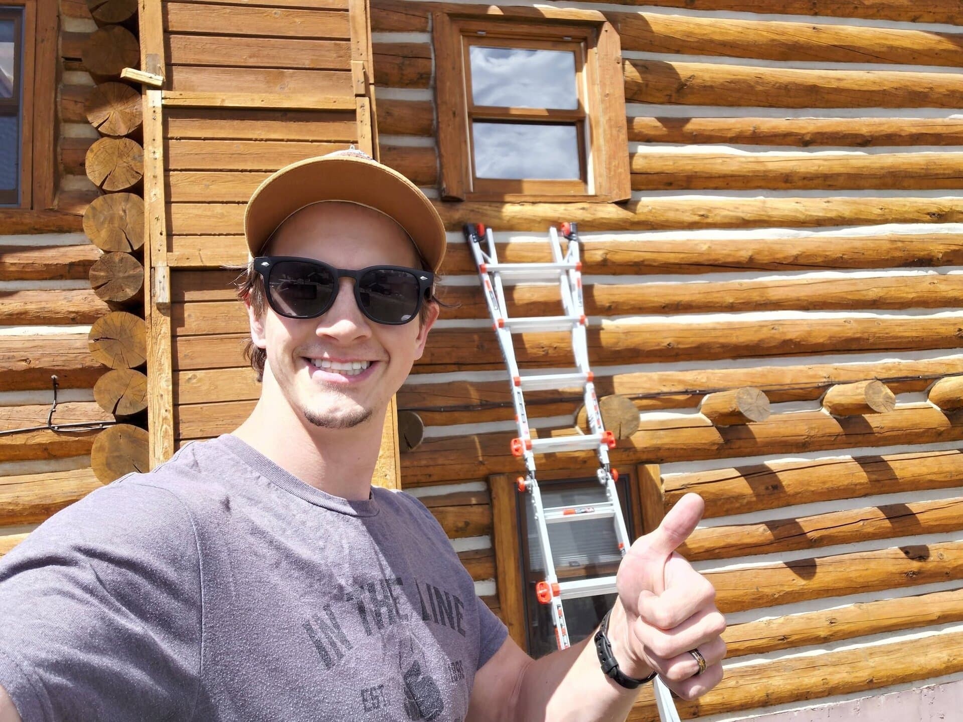 Josh on the job at a log home, ladder at the ready